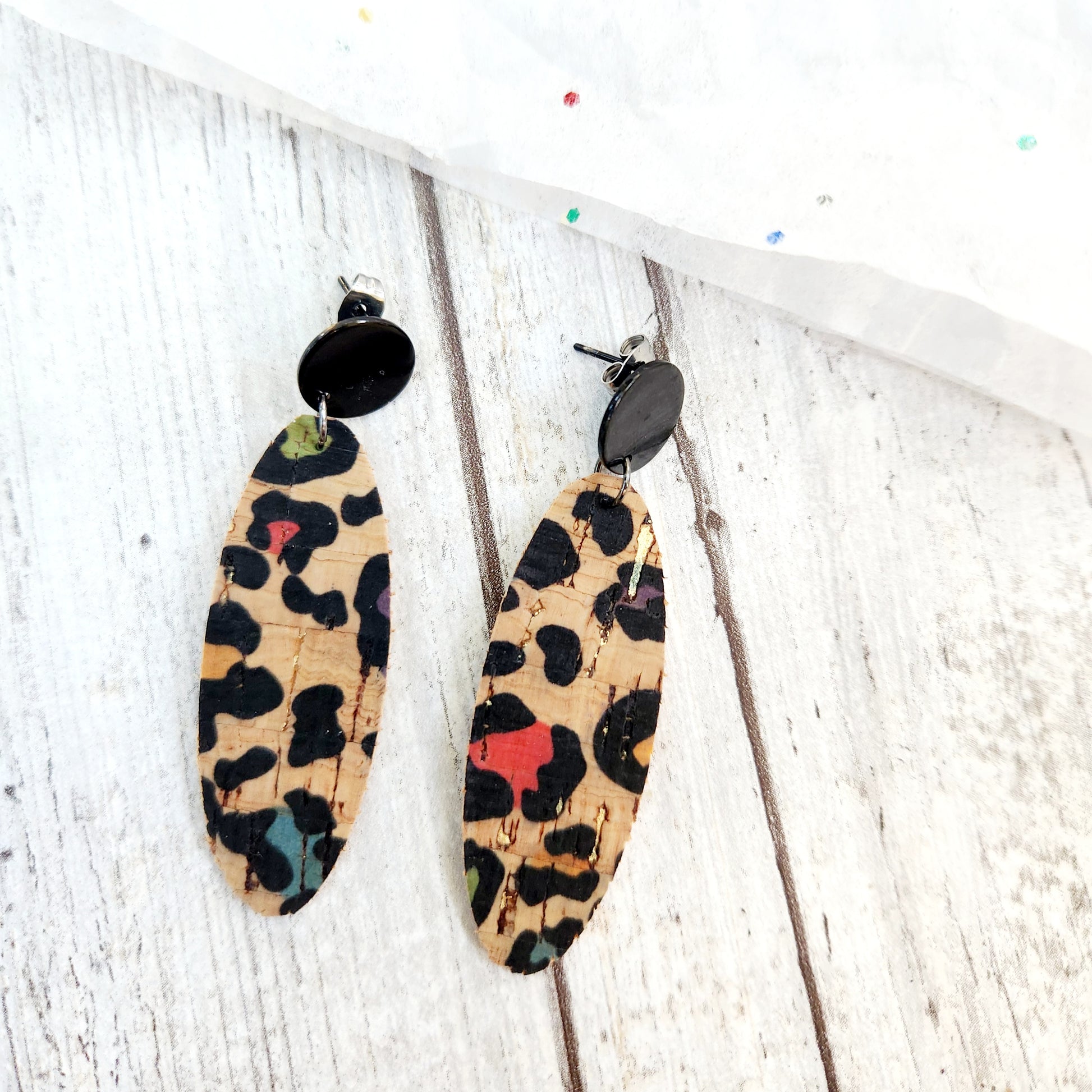 Bianca, natiral cork with a black leopard print woth green, red, yellow and blue in the spots. Hanging from a black circle stud.