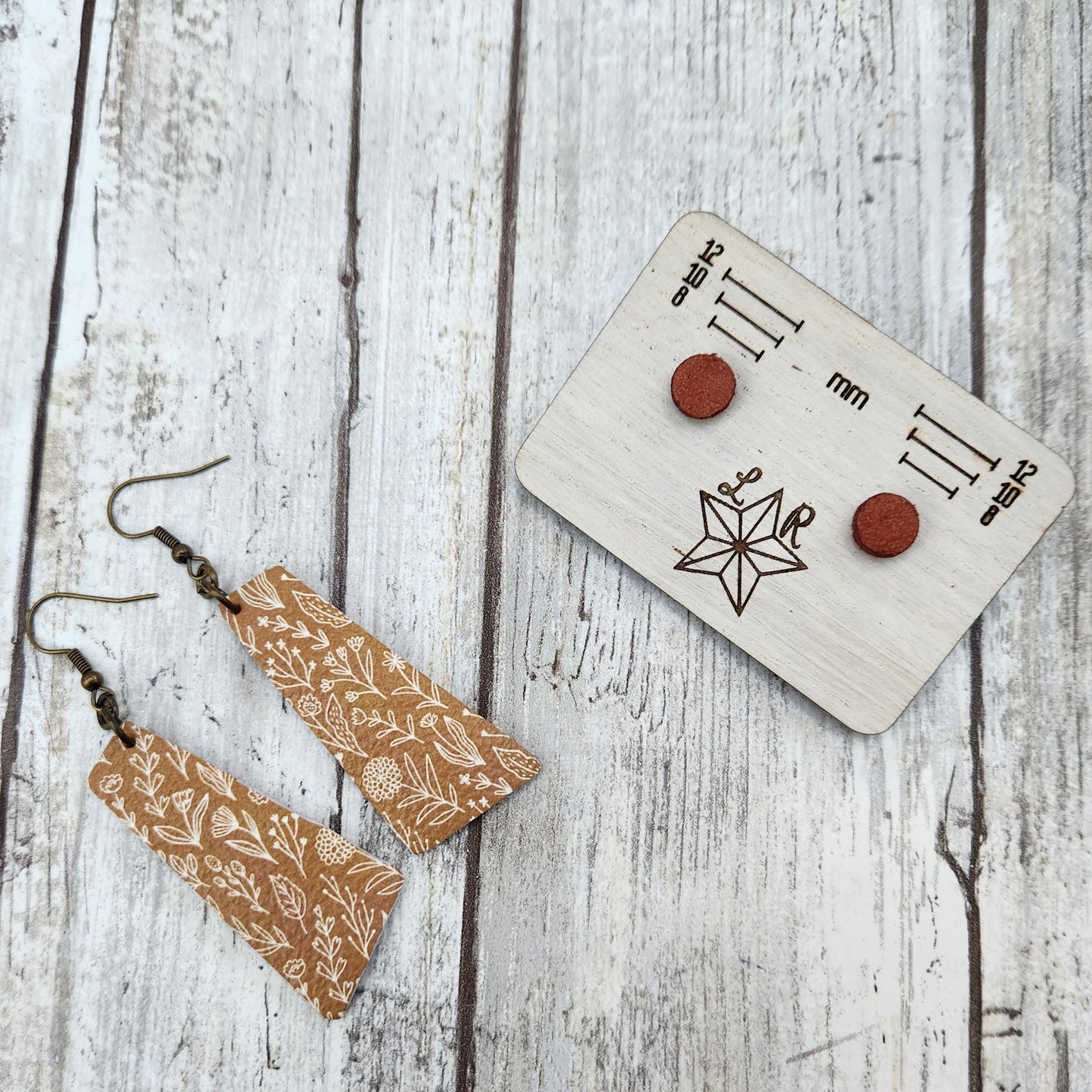 Fall themed leather earrings. With Andy, trapezoid shaped leather with a mustard background and white fall floral spray print. With sienna 8mm circle Lil studs.