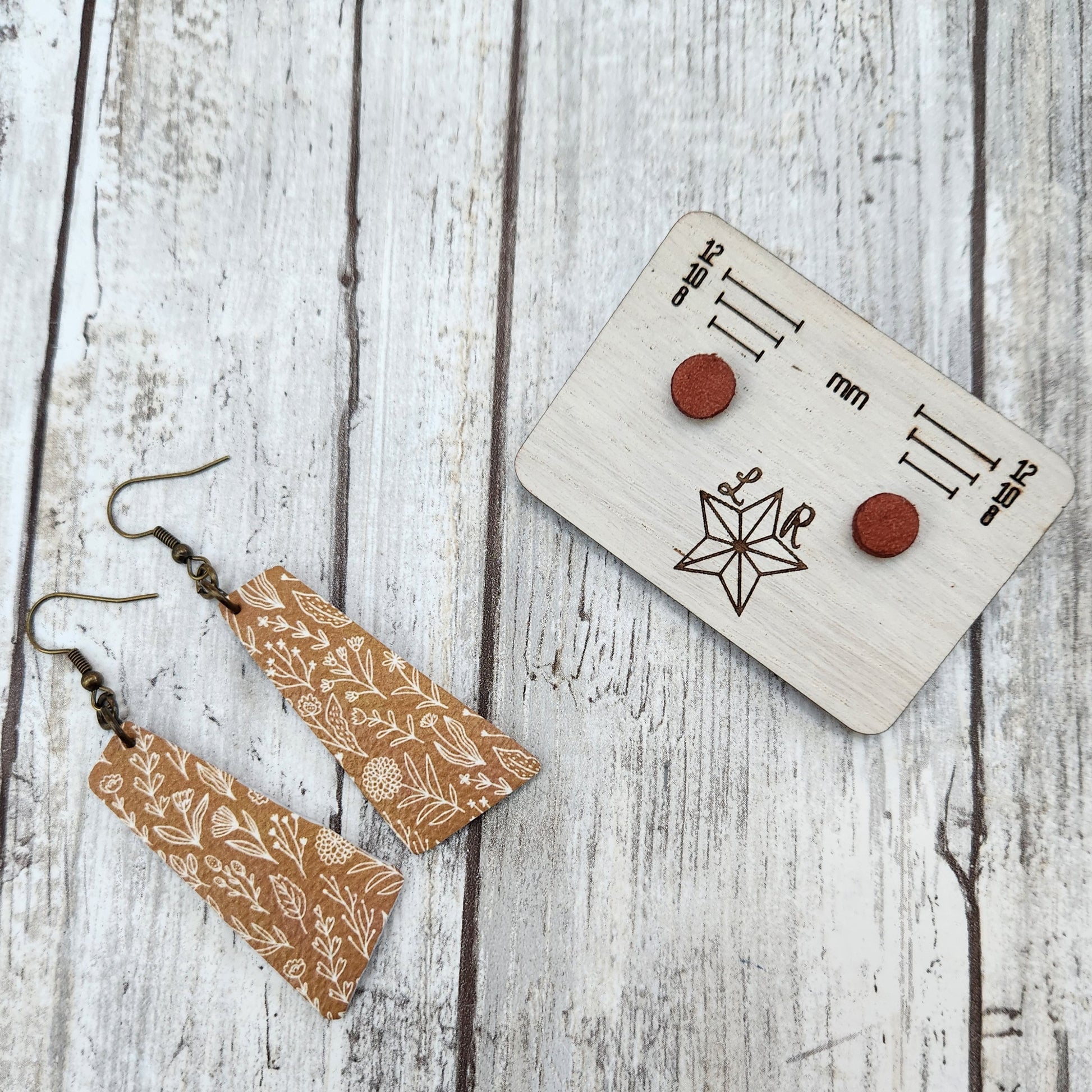 Fall themed leather earrings. With Andy, trapezoid shaped leather with a mustard background and white fall floral spray print. With sienna 8mm circle Lil studs.