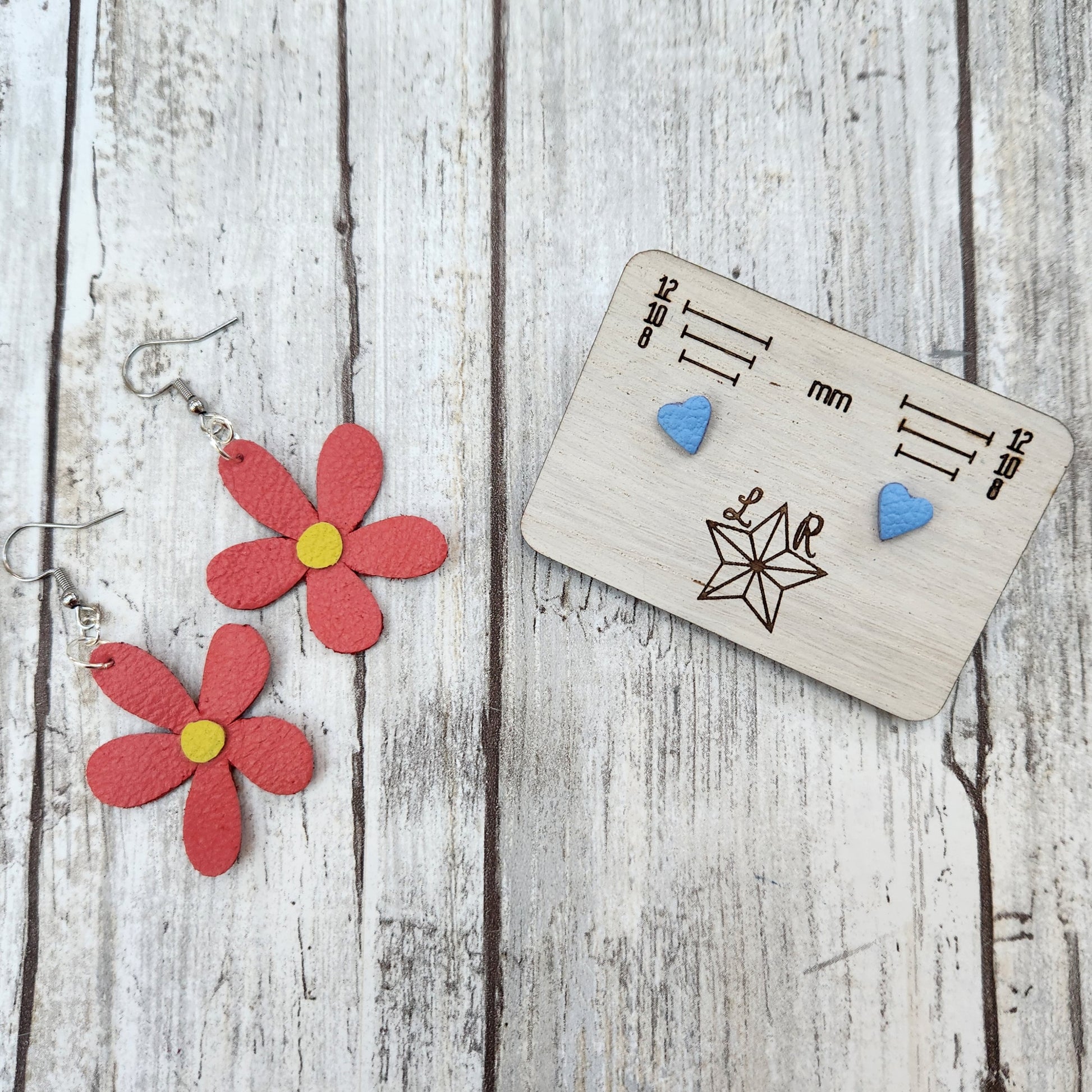 Spring themed leather earrings. Jaylee is a pink flower with a yellow center. Pastel blue Lil studs in heart.